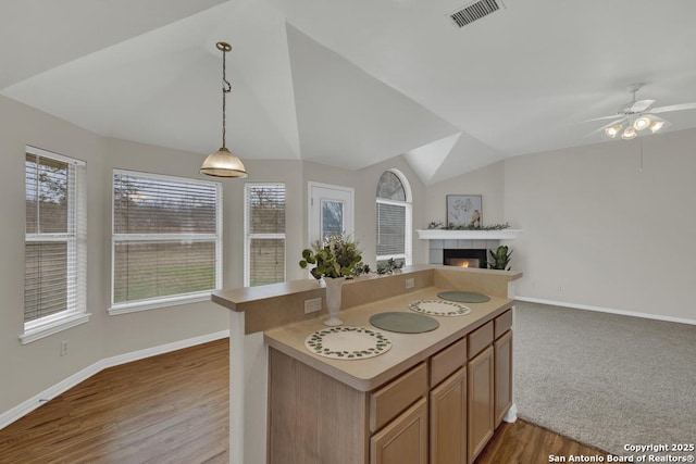 kitchen featuring decorative light fixtures, light countertops, visible vents, open floor plan, and vaulted ceiling