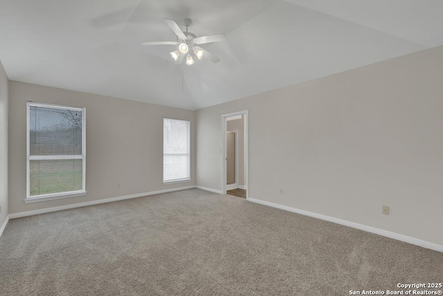 unfurnished room with ceiling fan, carpet floors, vaulted ceiling, and baseboards