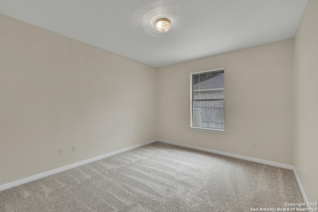 carpeted empty room with baseboards