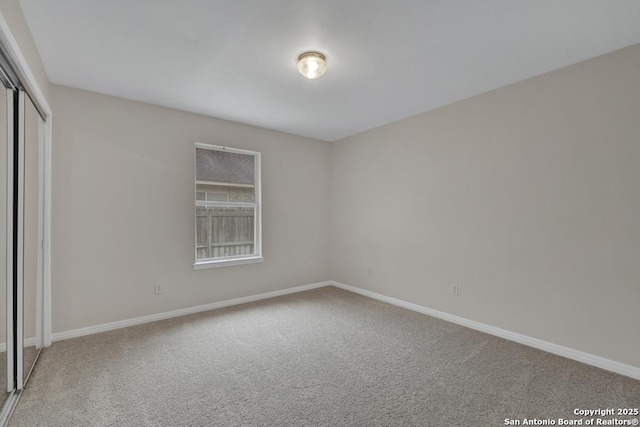 unfurnished bedroom featuring carpet, baseboards, and a closet