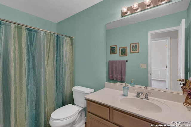 full bathroom with toilet, curtained shower, and vanity