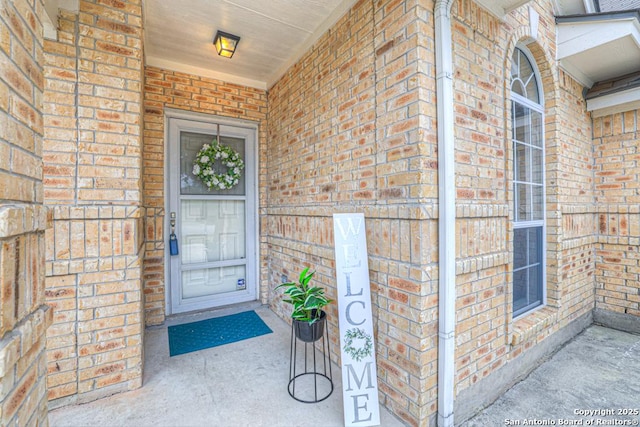 doorway to property featuring brick siding