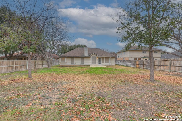 back of house featuring a lawn and a fenced backyard