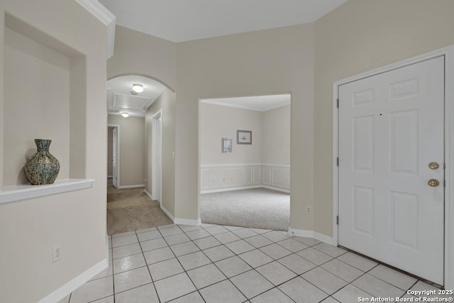 entrance foyer with light tile patterned floors, baseboards, and light colored carpet