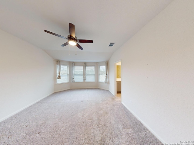 carpeted empty room featuring vaulted ceiling and ceiling fan