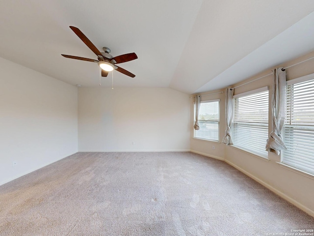 carpeted spare room with vaulted ceiling and ceiling fan