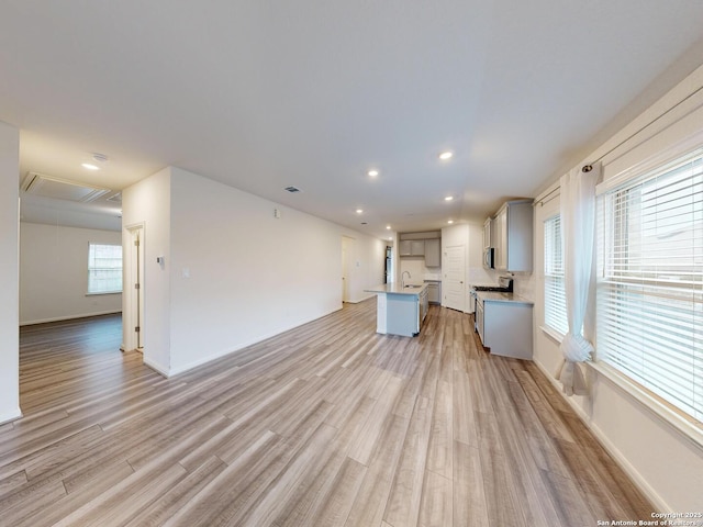 unfurnished living room with sink and light hardwood / wood-style flooring