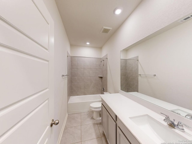 full bathroom featuring tiled shower / bath, vanity, toilet, and tile patterned flooring