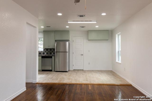 kitchen featuring tasteful backsplash, green cabinets, ceiling fan, stainless steel appliances, and light hardwood / wood-style floors