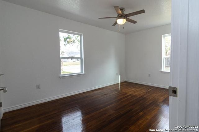 spare room featuring dark wood-type flooring and ceiling fan