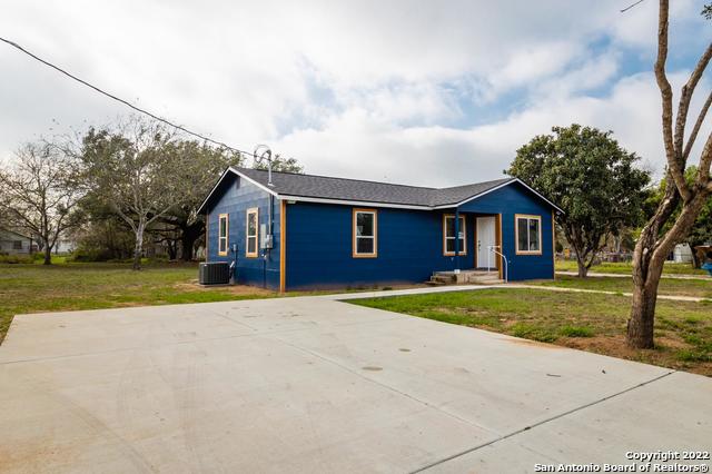 ranch-style house featuring central AC unit and a front yard