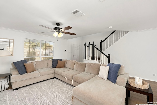 living room featuring ornamental molding, ceiling fan, and light wood-type flooring