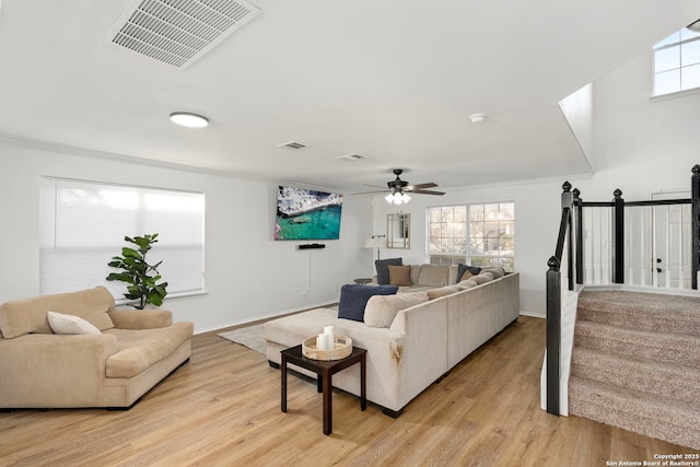 living room with crown molding and light wood-type flooring