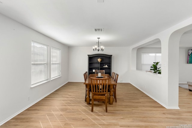 dining space featuring an inviting chandelier and light hardwood / wood-style flooring