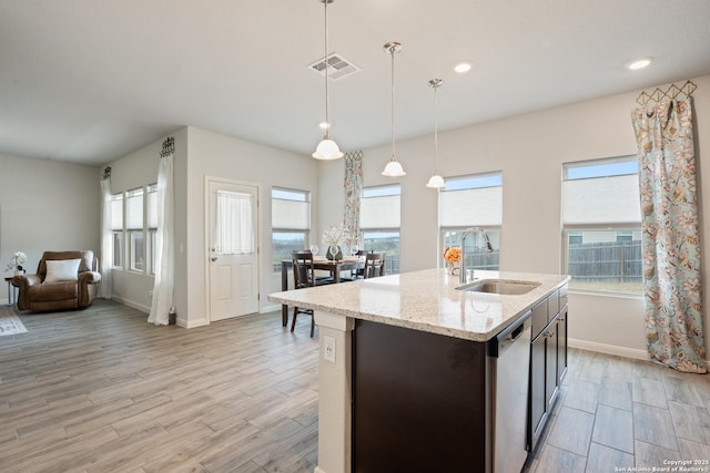 kitchen with visible vents, light wood-style floors, open floor plan, a sink, and dishwasher