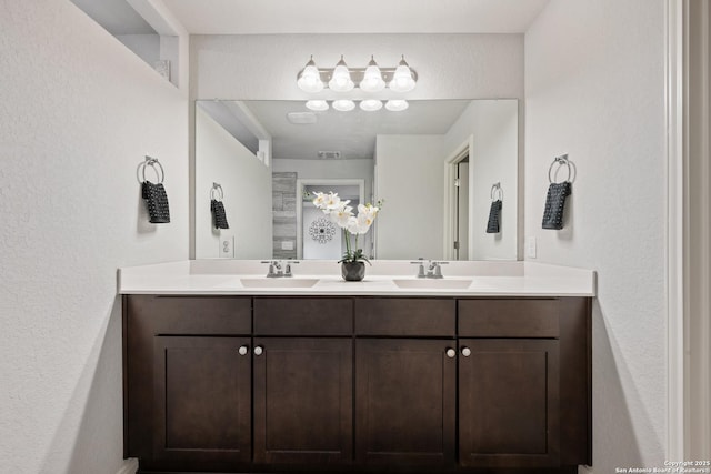 full bath featuring double vanity, a sink, and visible vents