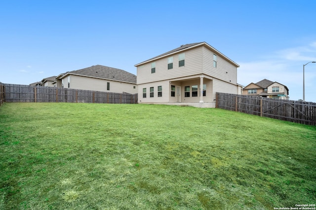 back of property featuring a lawn and a fenced backyard