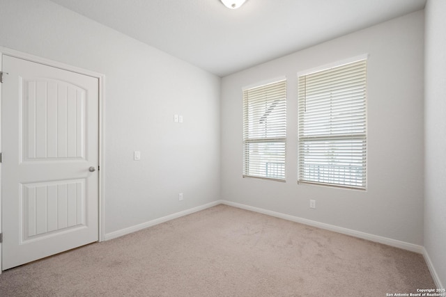 empty room featuring baseboards and carpet flooring