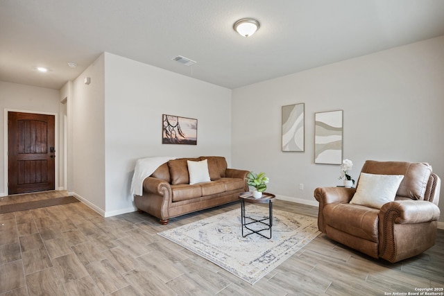 living area featuring light wood-type flooring, visible vents, and baseboards