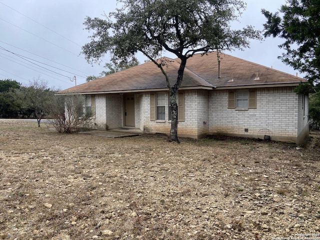 rear view of house with crawl space and brick siding