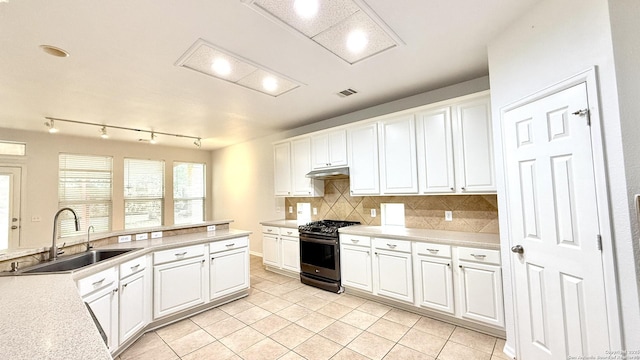 kitchen with white cabinetry, sink, decorative backsplash, and stainless steel range with gas stovetop