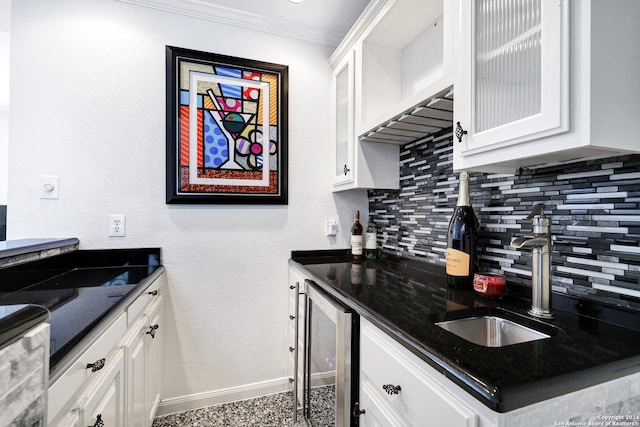 kitchen with white cabinetry, beverage cooler, and tasteful backsplash