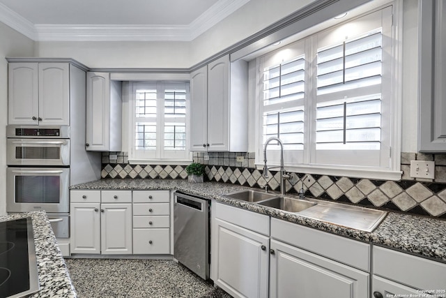 kitchen featuring stainless steel appliances, ornamental molding, and white cabinets