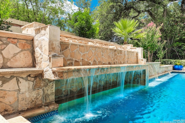 view of swimming pool with pool water feature