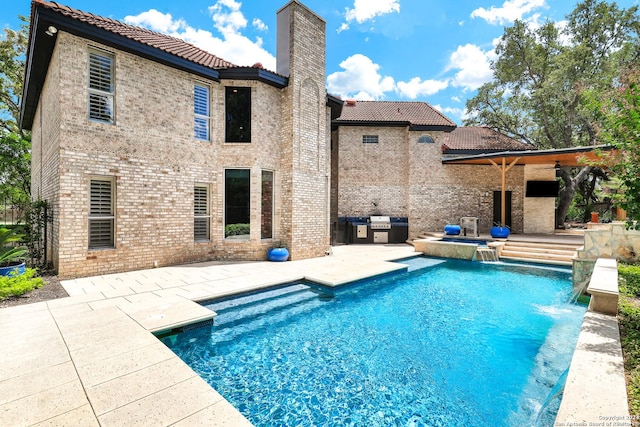 view of swimming pool featuring pool water feature, an in ground hot tub, and a patio