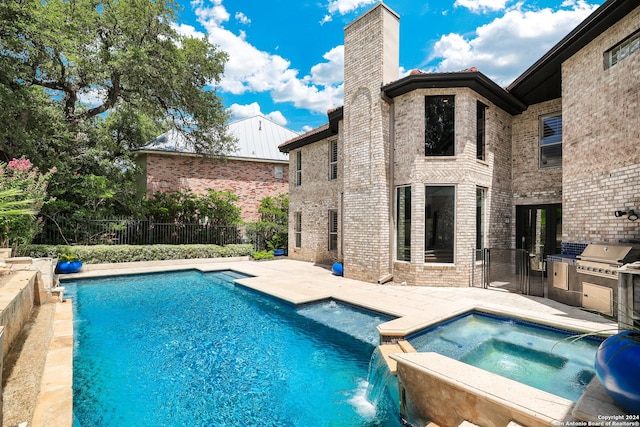 view of swimming pool featuring a patio area, pool water feature, and an in ground hot tub