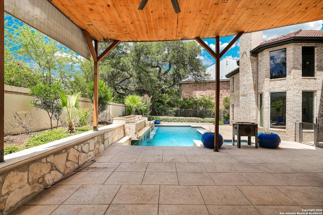 view of pool with a patio, pool water feature, and ceiling fan