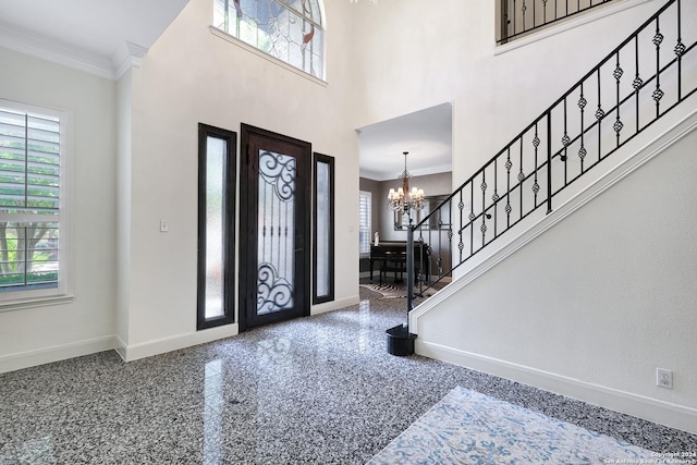 foyer featuring crown molding, a chandelier, and a high ceiling