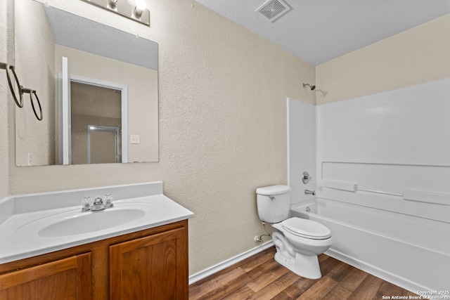 full bathroom with toilet, a textured ceiling, vanity, shower / bath combination, and hardwood / wood-style floors