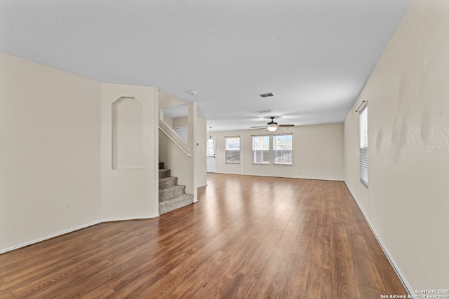 unfurnished living room with ceiling fan and wood-type flooring