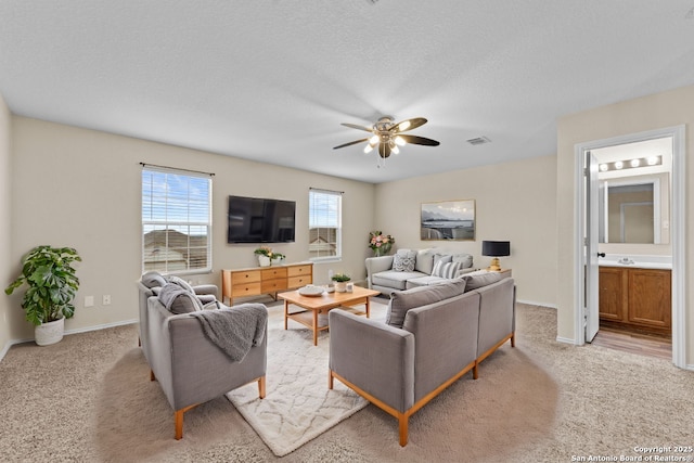 living room featuring light carpet, a textured ceiling, and ceiling fan