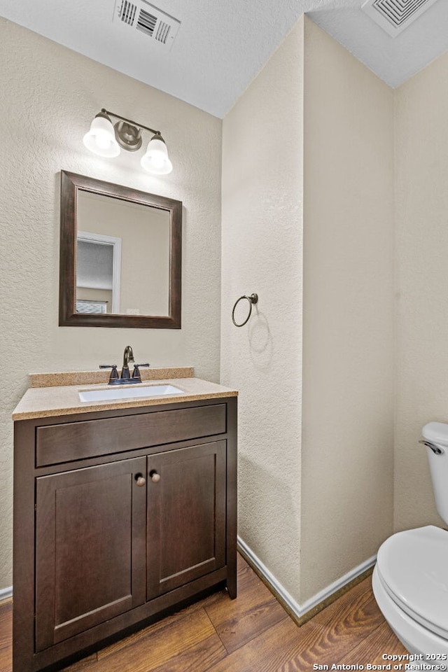 bathroom featuring hardwood / wood-style flooring, vanity, and toilet