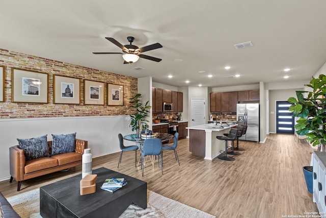 living room with light hardwood / wood-style floors and ceiling fan