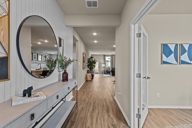 hall with sink and light wood-type flooring