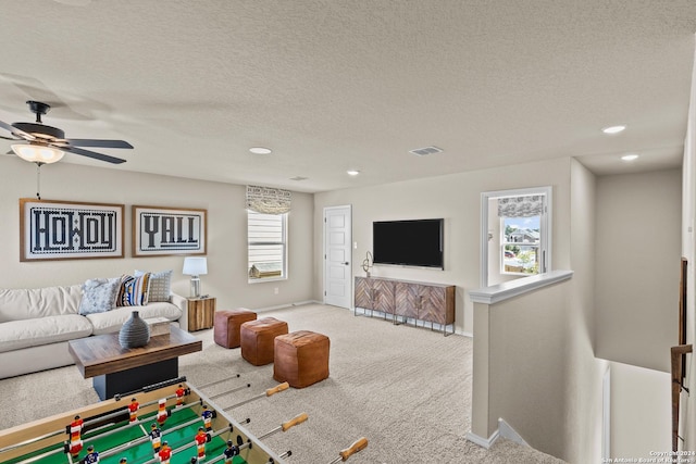 living room featuring ceiling fan, a textured ceiling, and carpet flooring