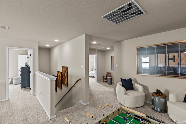 playroom with carpet floors and a textured ceiling