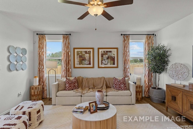 living room featuring ceiling fan, a wealth of natural light, and light hardwood / wood-style floors