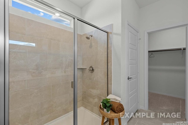 bathroom with an enclosed shower and tile patterned floors