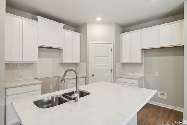 kitchen featuring a kitchen island with sink, sink, white cabinets, and dark hardwood / wood-style floors