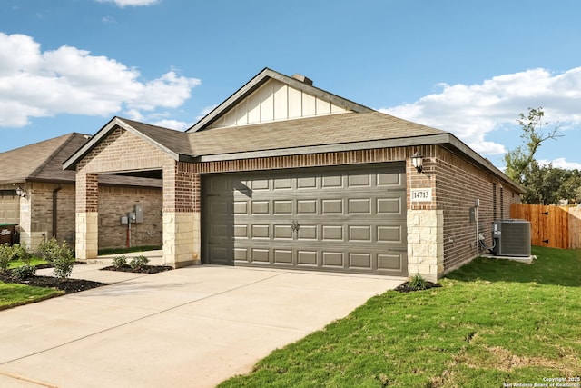 view of front of home featuring central AC, a garage, and a front lawn