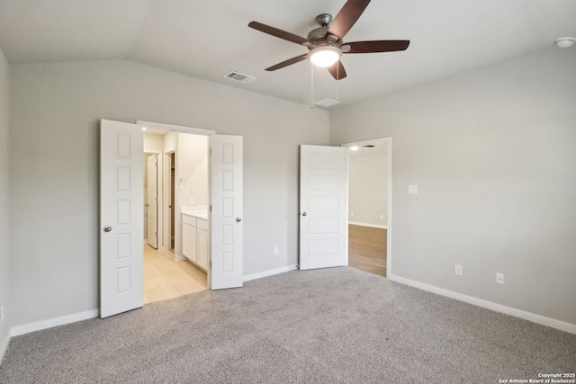 unfurnished bedroom with ceiling fan, lofted ceiling, light colored carpet, and ensuite bath