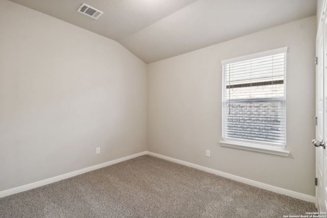 empty room featuring vaulted ceiling and carpet