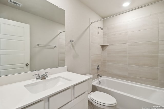 full bathroom with tiled shower / bath combo, vanity, and toilet