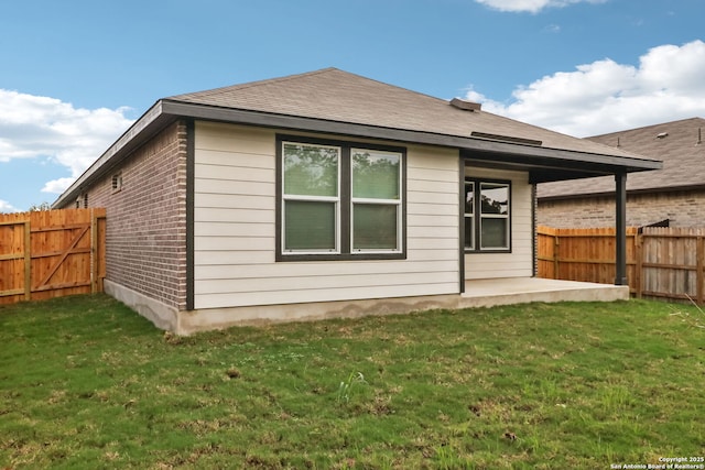 back of house with a yard and a patio area