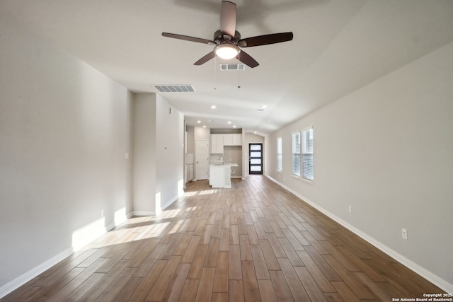 unfurnished living room featuring wood-type flooring, ceiling fan, and vaulted ceiling