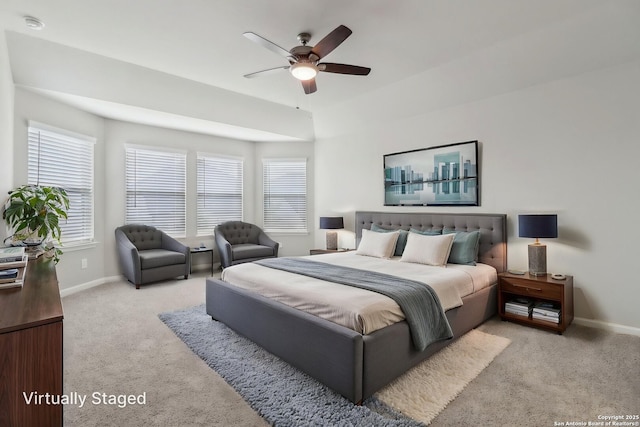 bedroom featuring light colored carpet, baseboards, and a ceiling fan